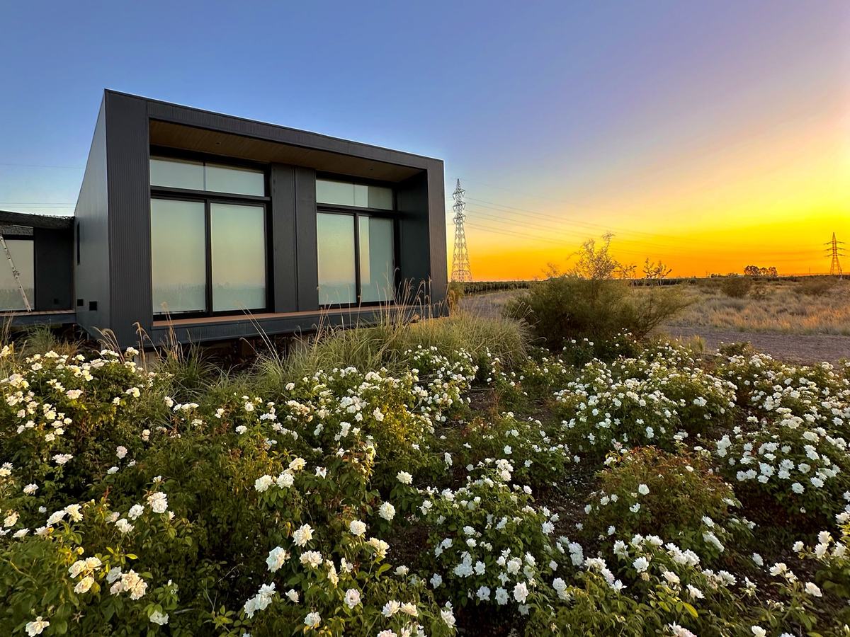 El casco de la finca al atardecer, rodeado de flores